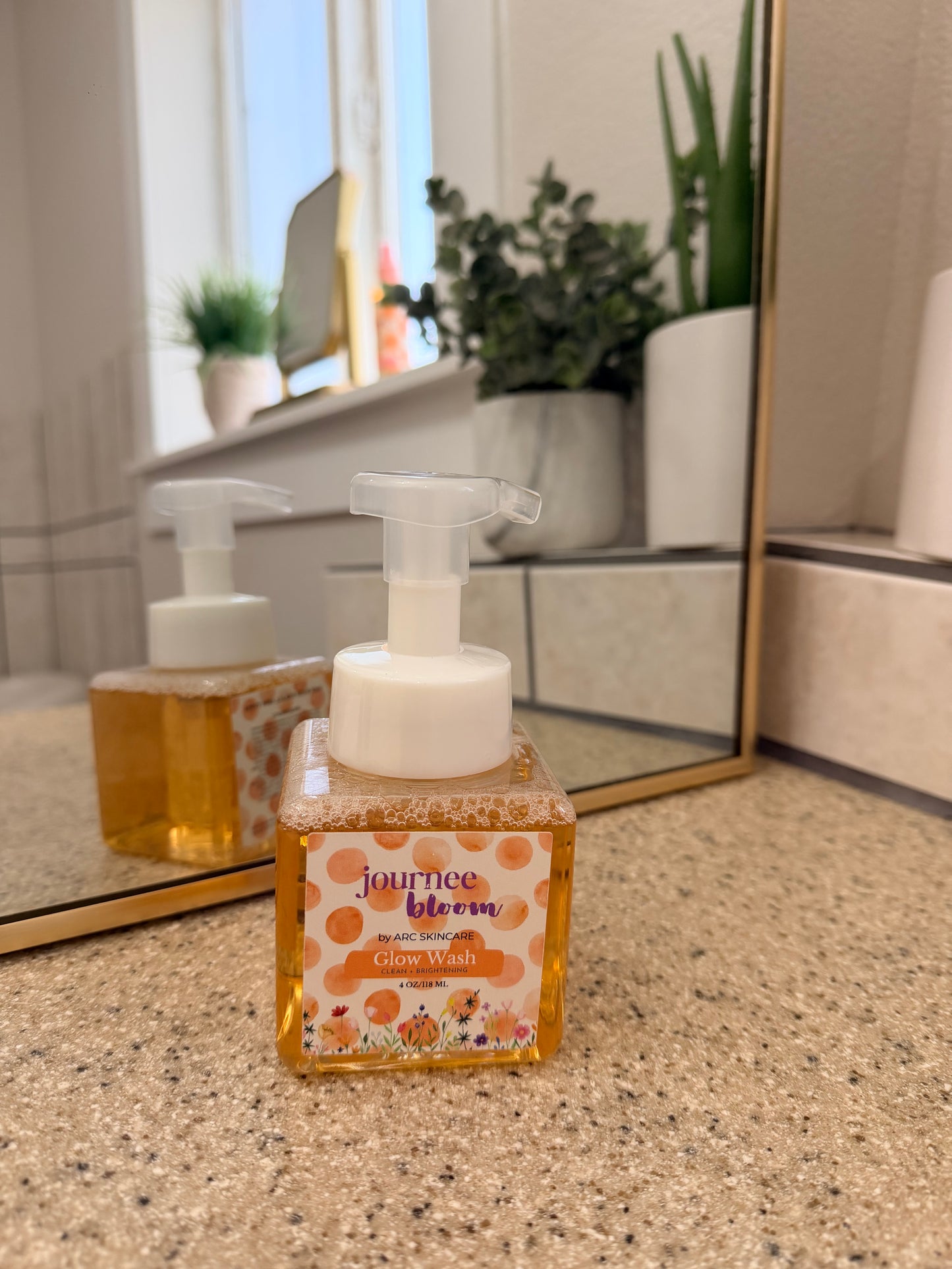 Hand soap dispenser on a bathroom counter with a window in the background