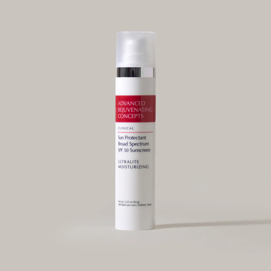 A bottle of Sun Protectant Ultralite Sheer, which is a moisturizing sunscreen with SPF 50. The bottle is white with a red label and a black cap.